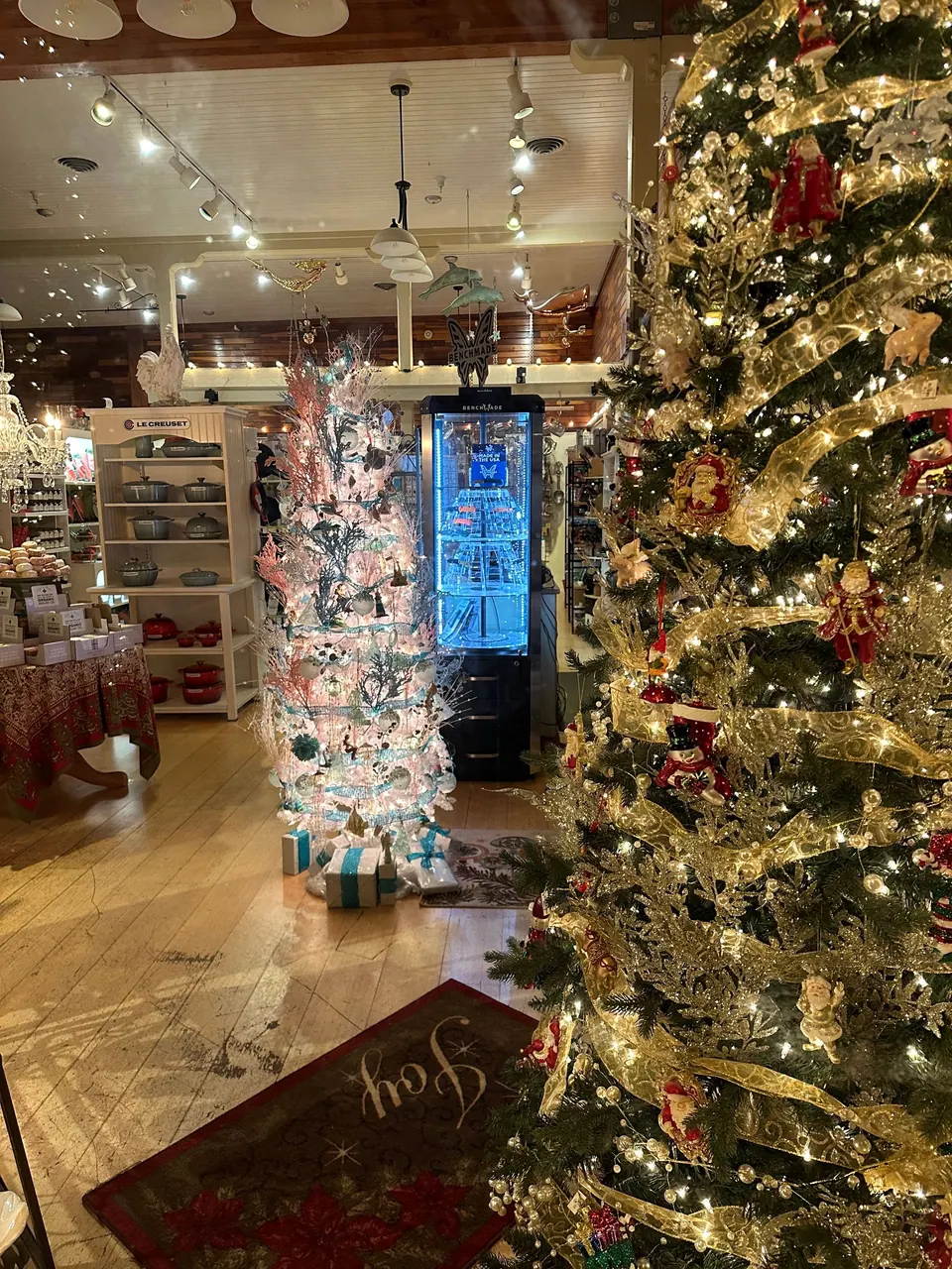 The lit inside of a gift shop full of decorated Christmas trees and displays.